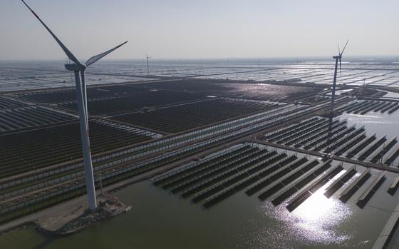 Wind turbines and a solar farm are seen from above.