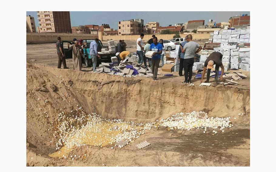 People dispose of rotten eggs, part of aid packages for Gaza that had gone bad while sitting in the sun at the Rafah crossing, which has remained closed, amid the ongoing conflict between Israel and the Palestinian Islamist group Hamas, in Rafah, Egypt, May 22, 2024.