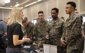 Robyn Cameron, a Recruitment Specialist with Southeast Lineman Training Center, speaks with U.S. Marines during a SkillBridge expo at Camp Lejeune, N.C., in February 2023.