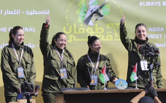 Israeli female soldier hostages wave and react at a Palestinian crowd before being handed over to the Red Cross in Gaza City, Saturday, Jan. 25, 2025. (AP Photo/Abed Hajjar)