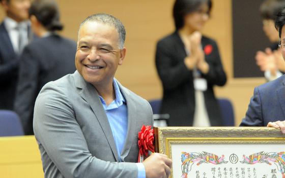 Dave Roberts holds an award during a ceremony in Naha.