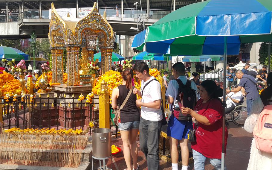 People light incense at a shrine.