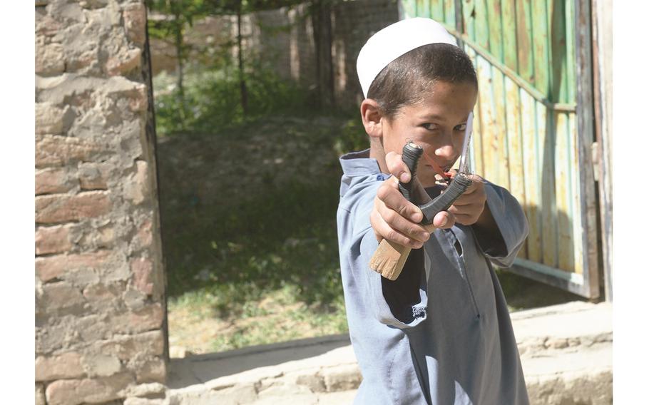 Afghan child shows off his slingshot 