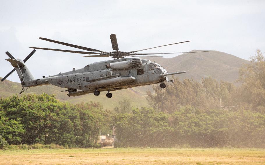 A Marine helicopter is seen hovering near the ground.