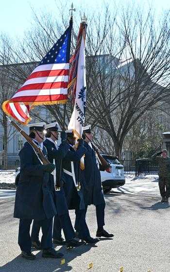 Coast Guard members carry the U.S. flag and the service flag.