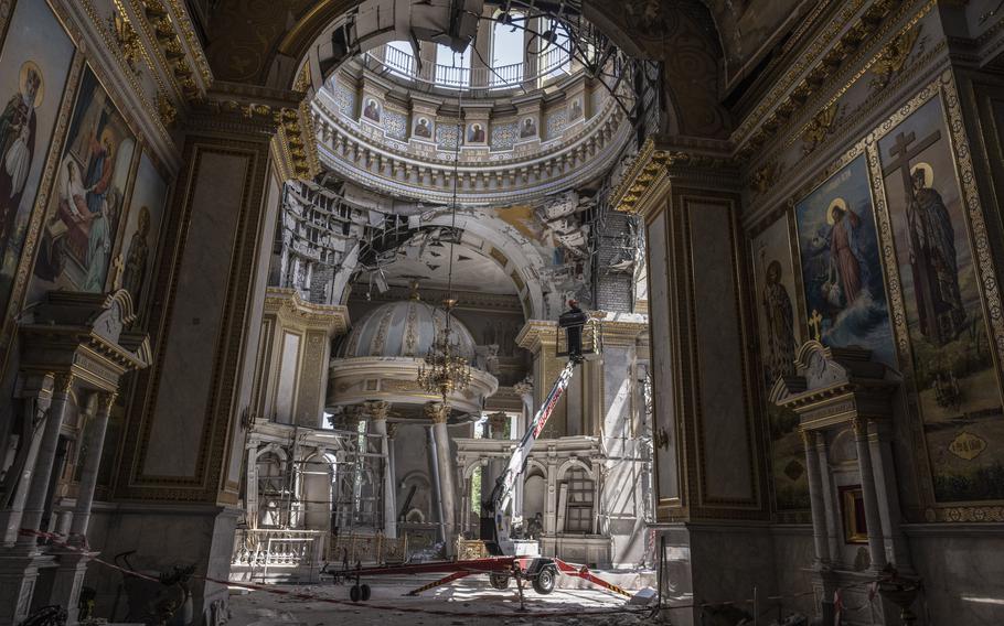 Workers use a crane inside the heavily damaged Transfiguration Cathedral, a religious structure that was previously destroyed by Soviet authorities in 1936. 