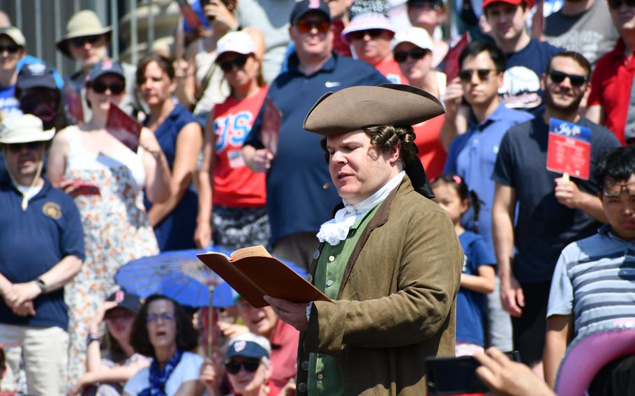 A reenactor portraying John Hancock reads a list of grievances to King George III on the steps of the National Archives on July 4, 2024.