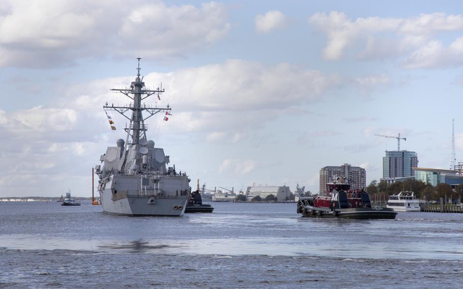 Tugboats maneuver USS Gravely out to sea as the ship gets underway for sea trials in 2020.