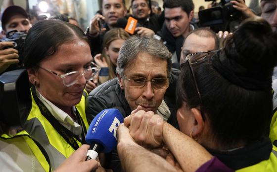 Fabio Ochoa, center, a former member of Cartel of Medellin, kisses a relative's hand upon his arrival at El Dorado airport, after being deported from the United States, in Bogota, Colombia, Monday, Dec. 23, 2024. (AP Photo/Fernando Vergara)