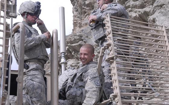Tangi District, Afghanistan, Oct. 17, 2009: Pfcs. John Gudzelak, 23, left, and Justin Griffin, 19, members of a route-clearing patrol with the 10th Mountain Division, joke around after their armored vehicle was struck by a bomb set off by a trigger man in the hostile Tangi valley of eastern Afghanistan's Wardak province earlier that day. The mine-sweeping vehicle was damaged but its armor was not penetrated by the blast, and the two soldiers were knocked out but not badly hurt.

META DATA: Afghanistan; Operation Enduring Freedom; IED; TBI; U.S. Army