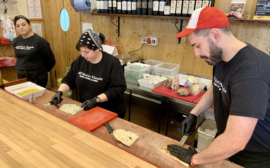 Workers at an Italian shop prepare sandwiches for customers.