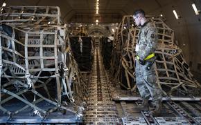 A U.S. airman observes while tactical vehicles, bound for Ukraine, are secured inside a commercial aircraft at Dover Air Force Base, Del., Jan. 20, 2023. A recent Defense Department Inspector General report found that at least $1.1 billion in Ukraine aid lacked adequate documentation. 