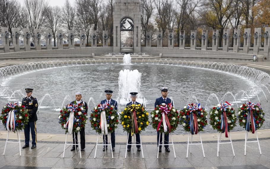 Service members behind wreaths at the memorial.