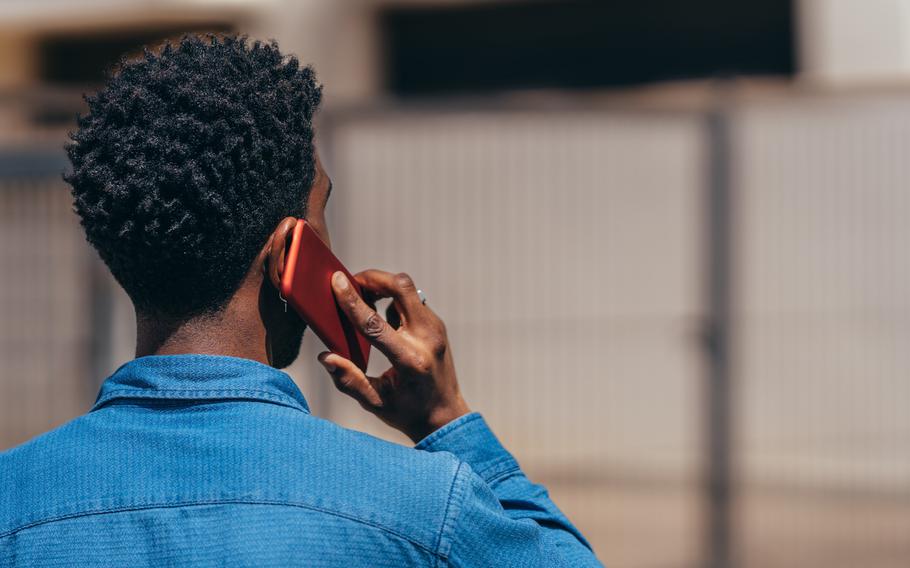 Back view of young African American man talking on mobile phone outdoors