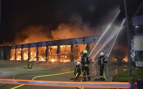 Firefighters try to extinguish a fire in a vehicle depot in Stadtallendorf, Germany, Wednesday Oct. 16, 2024. (Michael Rinde/dpa via AP)