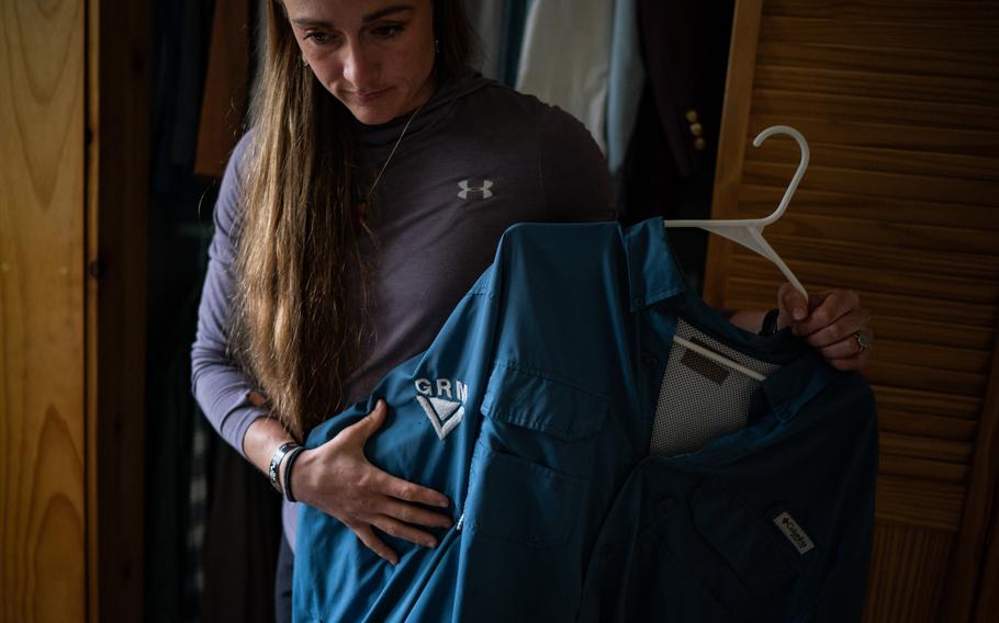 Alex Potter holds some of her husband’s favorite shirts.