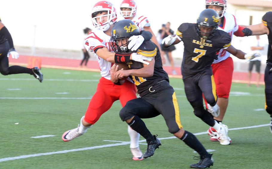 Kinnick's Joseph Mauldin tries to wrestle down Kadena running back Hajime Reed.