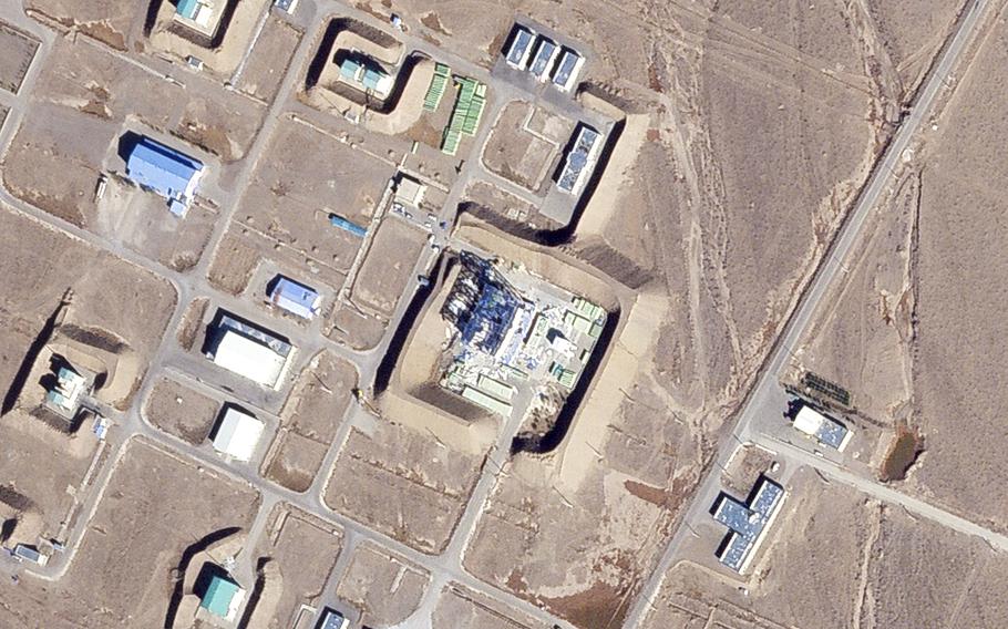 An overhead satellite image of a damaged building in a desert setting.