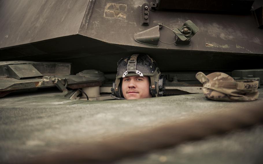 A tank driver looks out of an M1A2 Abrams tank. 