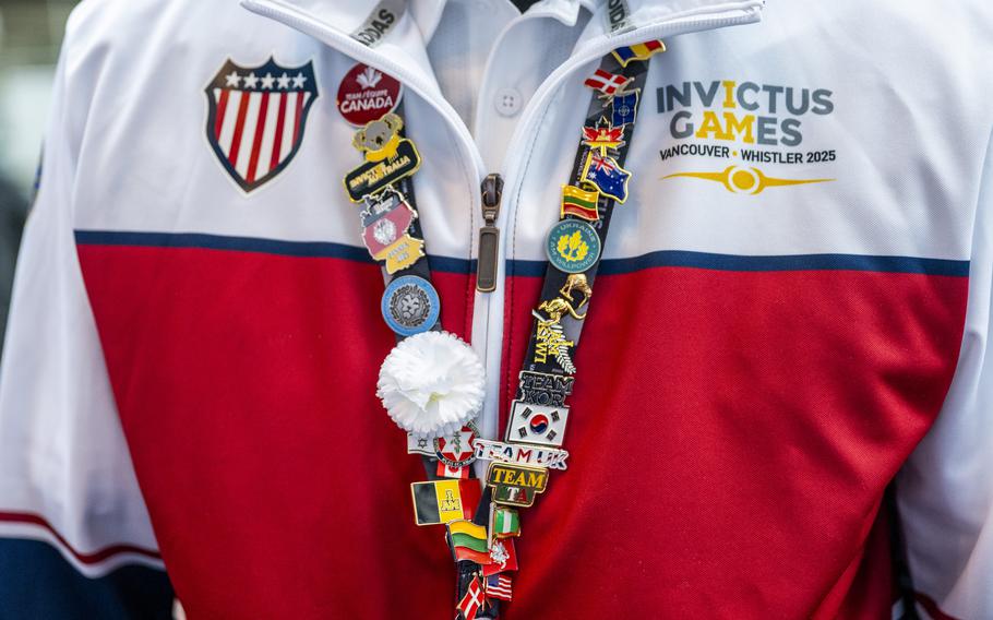 A competitor competes in indoor rowing wears a lanyard filled with pins