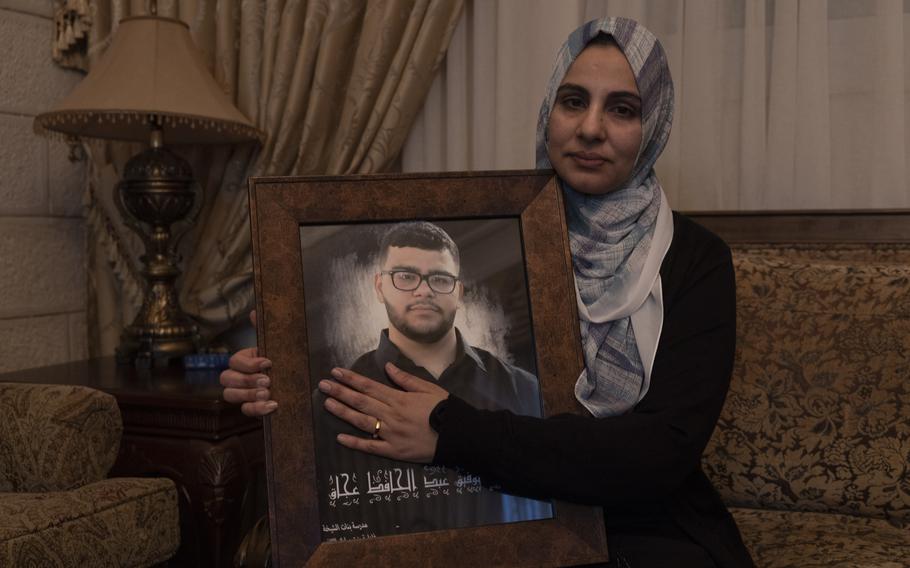 Mona Abdel Jabbar holds a photo of her late son, Tawfic Abdel Jabbar, who was killed in January.