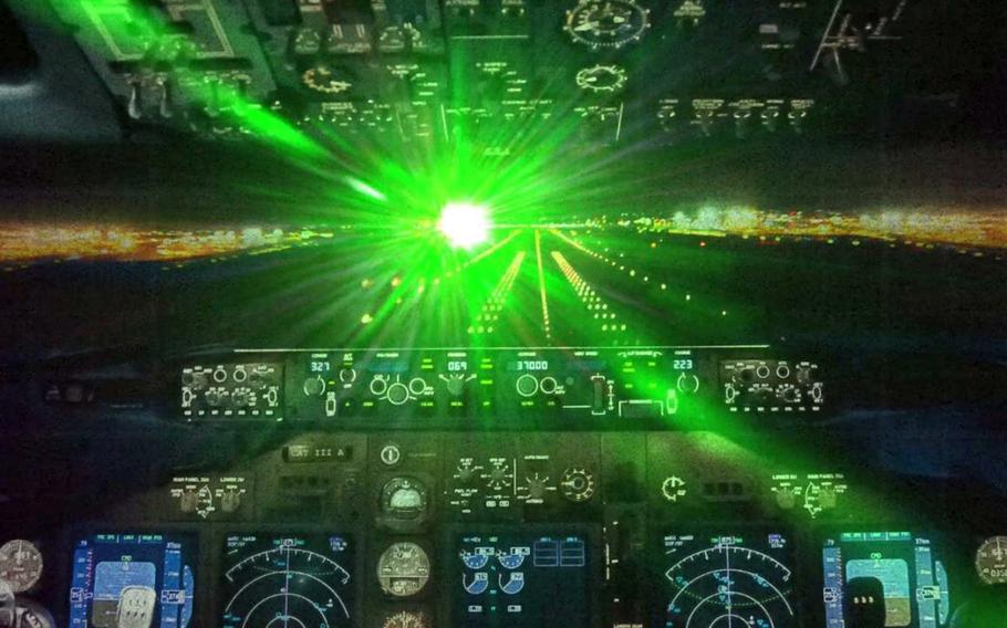 A bright green light shines into a cockpit. 