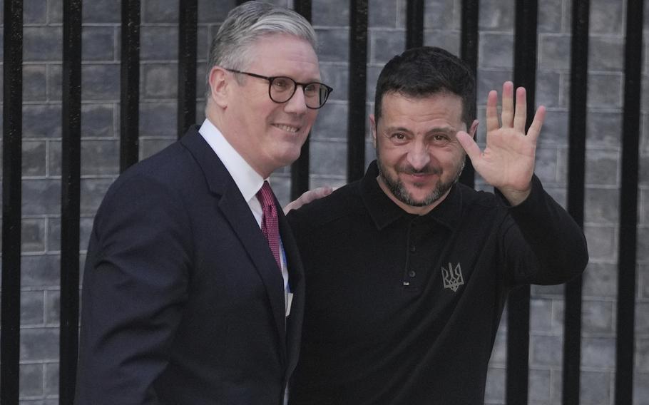 Britain’s prime minister greets Ukraine’s president, who waves at the camera.