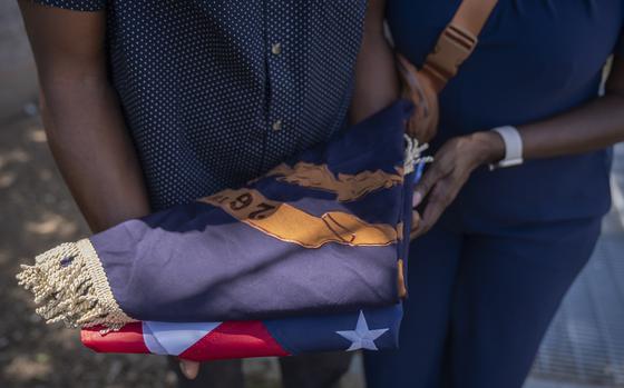 Associated Press reporter Darren Sands, left, and his wife Jummy Olabanji Sands, right, hold a U.S. flag and a flag from the 26th United States Colored Infantry, which his great-great-great-great grandfather Hewlett Sands served in, at the African American Civil War Memorial during Juneteenth commemorations on Wednesday, June 19, 2024, in Washington. (AP Photo/Mark Schiefelbein)
