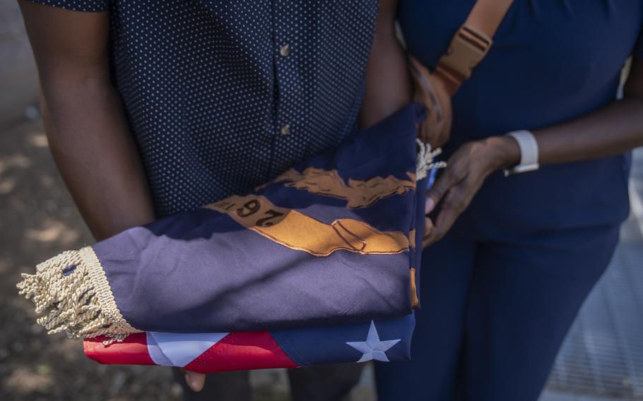 Associated Press reporter Darren Sands, left, and his wife Jummy Olabanji Sands, right, hold a U.S. flag and a flag from the 26th United States Colored Infantry, which his great-great-great-great grandfather Hewlett Sands served in, at the African American Civil War Memorial during Juneteenth commemorations on Wednesday, June 19, 2024, in Washington. 