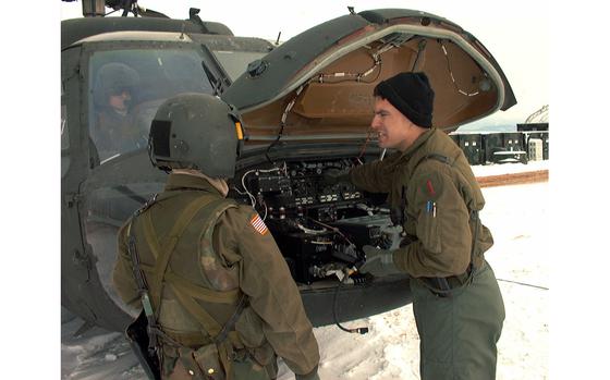 Camp Bondsteel, Kosovo, Feb. 18, 2000: Staff Sgt. Lee Kline and Spc. Raymond Jugal, both from B Company, 2nd Battalion, 1st Aviation, check the radio system on a UH-60L Blackhawk helicopter.

META TAGS: Kosovo; KFOR peacekeeping mission; ethnic violence; Albanians; Serbs; NATO