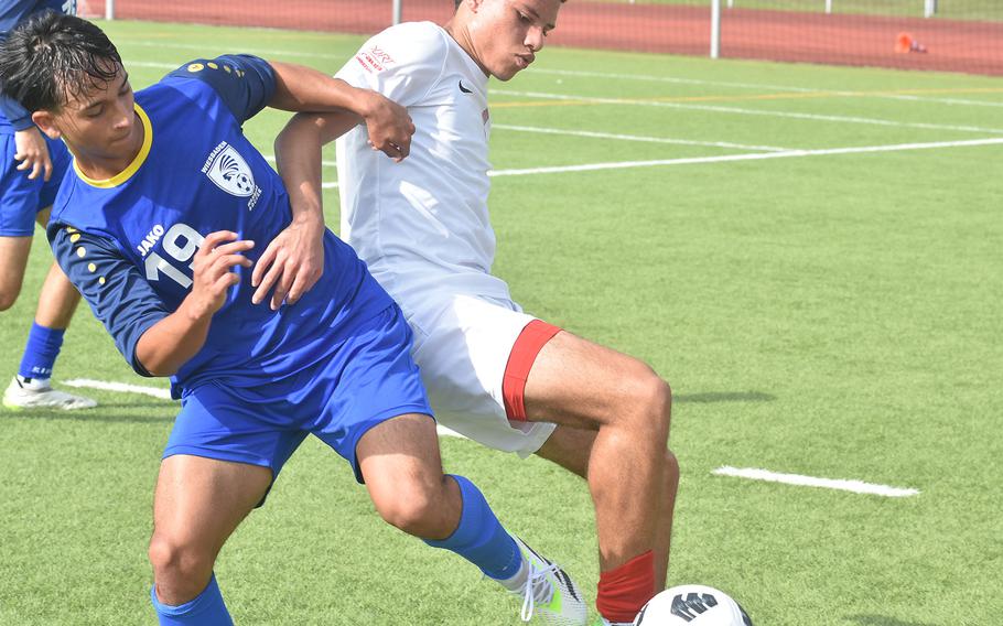 Kaiserslautern's Aaron Zamor, who scored two goals, battles with Wiesbaden's Jhon Colorado in the Raiders' 2-1 victory Monday, May 20, 2024, at the opening day of the DODEA European Division I boys soccer championships at Kaiserslautern High School.