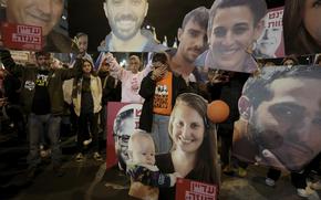 Protestors hold the portraits of hostages held by Hamas.