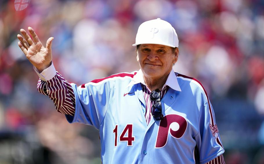 Pete Rose wears a Phillies jersey and white Phillies hat.