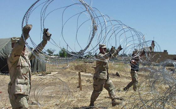 HED: Keeping the bad guys out, 2003

Kirkuk, Iraq, May 5, 2003: Air Force Master Sgt. Daniel Wear, Staff Sgt. Chip Davidson, and Staff Sgt. Brian Curtis, left to right, hoist a strand of concertina wire to help secure a living area. Security Forces airmen are working hard to secure the eight-square-mile air base at Kirkuk, Iraq. 

META TAGS: U.S. Air Force; Wars on Terror; Operation Iraqi Freedom; base security; 