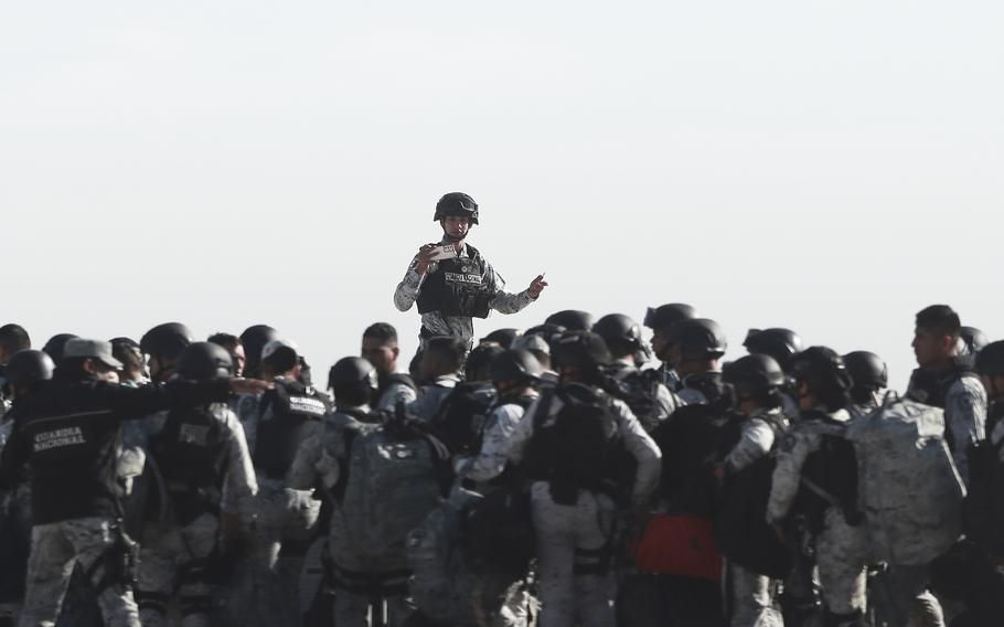 Mexican national guard members stand and listen to orders.