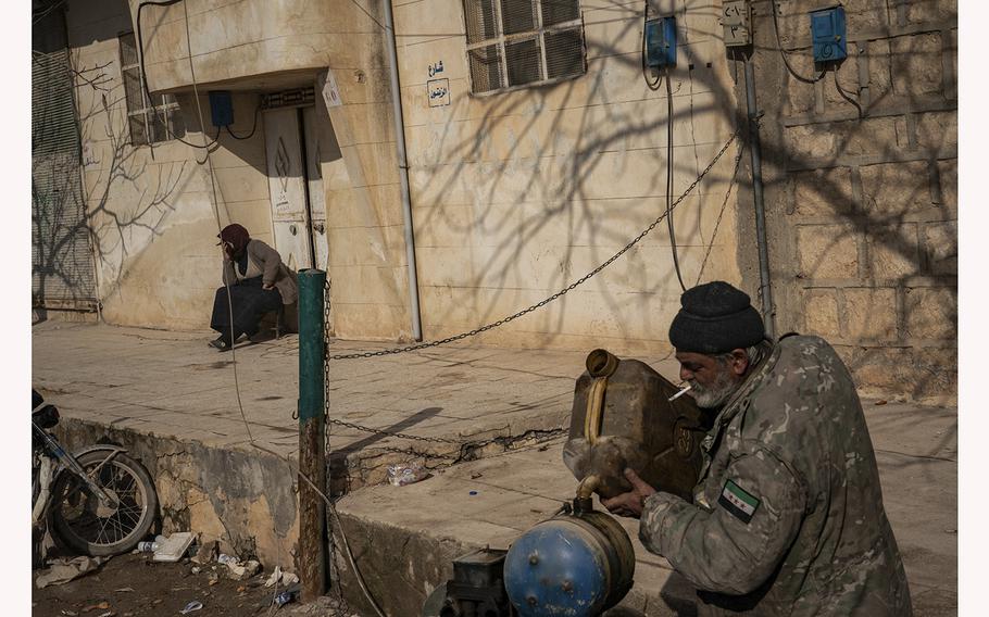 A man fills a generator with gasoline near the town of Jinderis, Syria, on Friday, Feb. 10, 2023.