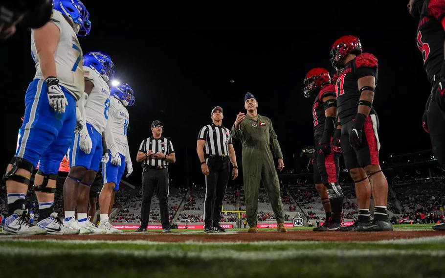 The Falcons, seen in blue and white, line up opposite players with San Diego State in red and black, with referees in the middle.