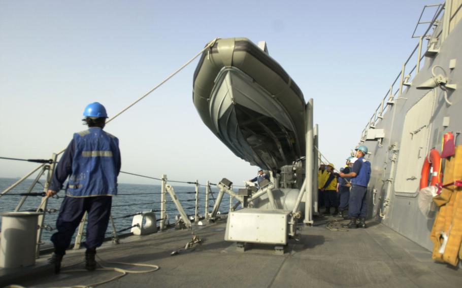 Sailors from USS Milius, a guided-missile destroyer, prepare to launch a rigid-hulled inflatable boat for maritime interception operations in the Persian Gulf, March 2003. The job of stopping smugglers from Iraq has been ongoing since 1990, but recently smugglers have been getting more creative at hiding their illegal cargo and more desperate to slip past the blockades.