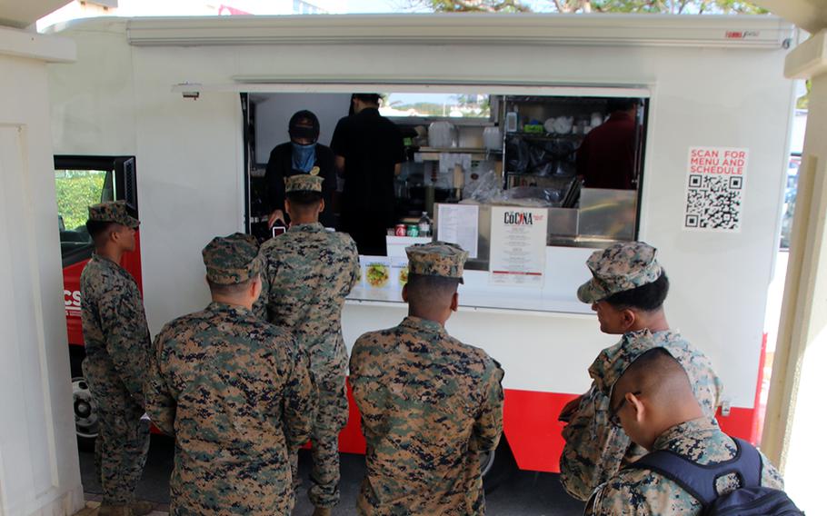 Marines queue to receive lunch at the government's expense through the Mobile Feeding Pilot Program at Camp Foster, Okinawa, Nov. 29, 2023.