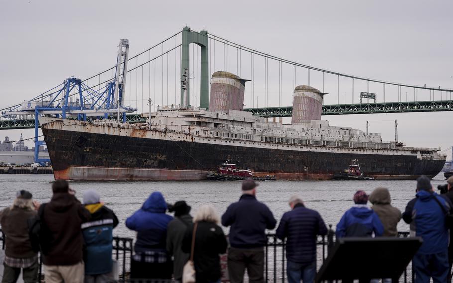 The SS United States is towed along the Delaware River