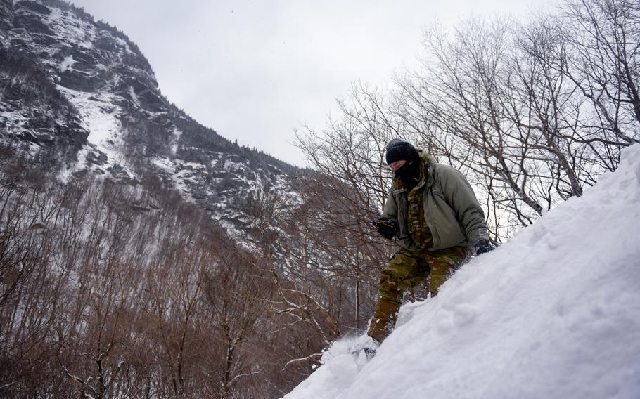 A student at the U.S. Army Mountain Warfare Schools descends in snowy terrain.