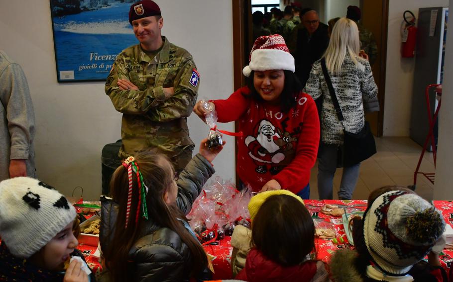 Ruth Batts, of the 54th Brigade Engineer Battalion soldier family readiness group, hands out candy to elementary students Dec. 5, 2023, during the battalion's annual toy drive in Camisano Vicentino, Italy.