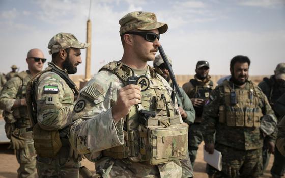 U.S. Army 1st Lt. Michael Wisniewski, an infantry officer assigned to Alpha Troop, 1st Squadron, 102nd Cavalry Regiment, 44th Infantry Brigade Combat Team, New Jersey National Guard discusses the significance of the 44th IBCT patch before presenting ceremonial patches as tokens of appreciation to members of the 1st Company, Syrian Armed Forces, near Al-Tanf Garrison, Syria, Oct. 31, 2024. Coalition Forces advise, assist, and enable Partner Forces to defeat ISIS at any time, in any place, across the region. (U.S. Army photo by Staff Sgt. Mahsima Alkamooneh)