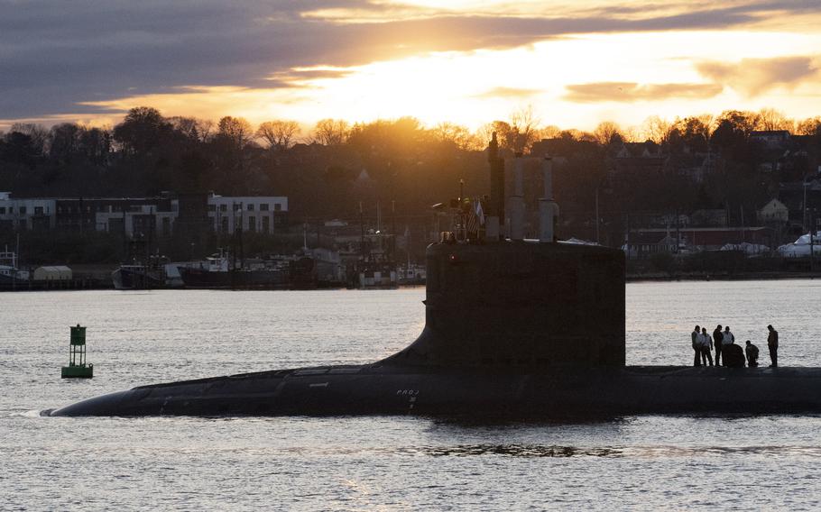 USS Indiana is silhouetted against a sunset.