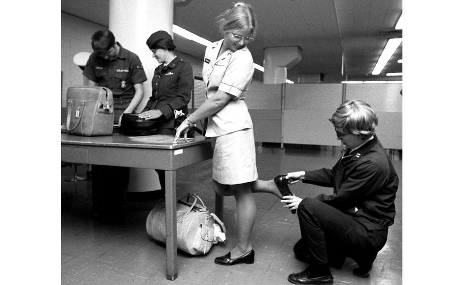 Yokota Air Base, Japan, March 1973: Lt. Caroline Thibodeau has the heel of her shoe checked by Capt. Joan Lesnikowski at a Yokota Air Base customs checkpoint as A1C Randall Hale searches Lt. Karen Wojtecki’s luggage. The two Army nurses were among 752 servicemembers on their way from South Vietnam to Travis AFB in California — the first wave of the last American troops to leave Vietnam.