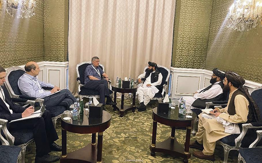 In this photo released by the Taliban Spokesman Office, Zabihullah Mujahid, the chief spokesman for the Taliban government who leads the Taliban delegation, center right, speaks with Russian Presidential Envoy to Afghanistan Zamir Kabulov, during a meeting in Doha, Qatar, Sunday, June 30, 2024. A Taliban delegation is attending a United Nations-led meeting in Qatar on Afghanistan after organizers said women would be excluded from the gathering. The two-day meeting is the third U.N.-sponsored gathering on the Afghan crisis. 