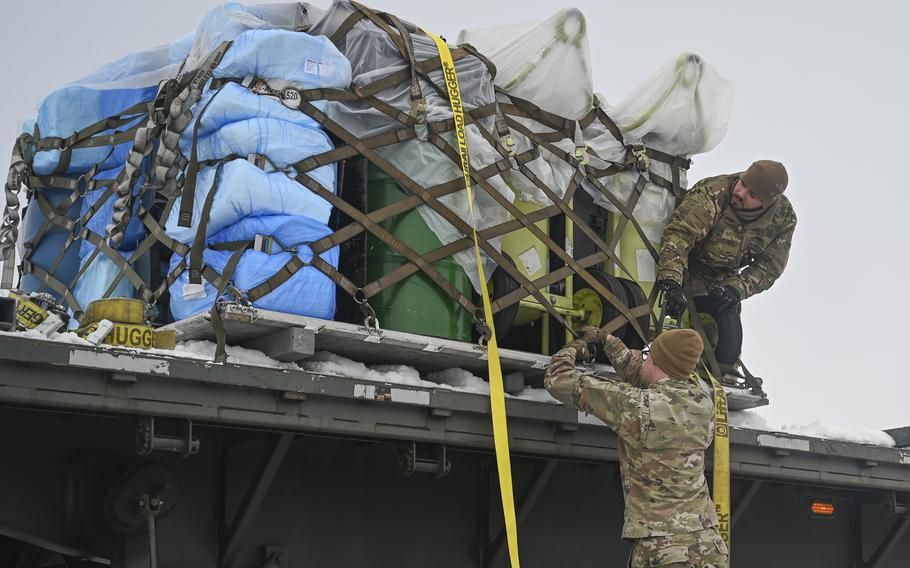 Senior Airman Austin Payton, left, and Staff Sgt. William Rios-Cruz,  unstrap cargo from a vehicle during Beverly Pack 25-1 at Kunsan Air Base, South Korea, Jan. 12, 2025.