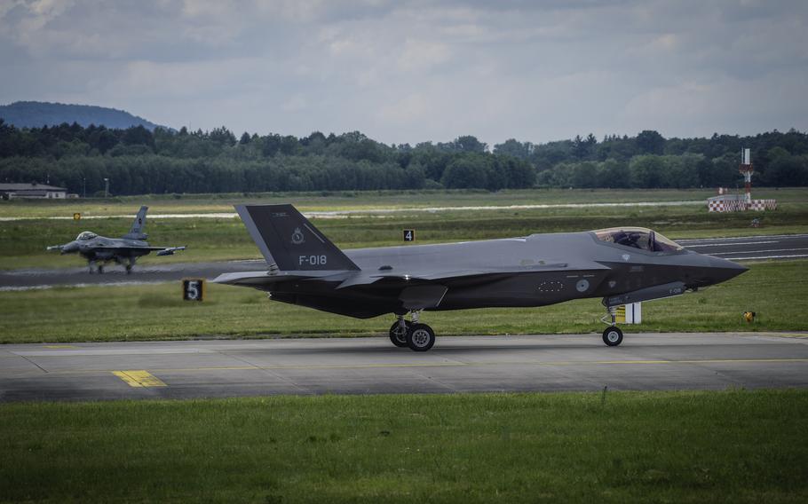 An F-35 Lightning II of the Dutch air force taxis after landing at Ramstein Air Base in Germany on June 6, 2024, accompanied by a Dutch F-16 Fighting Falcon. The base hosted a seven-hour exercise involving 37 fighter jets flying in waves to test their combat skills.