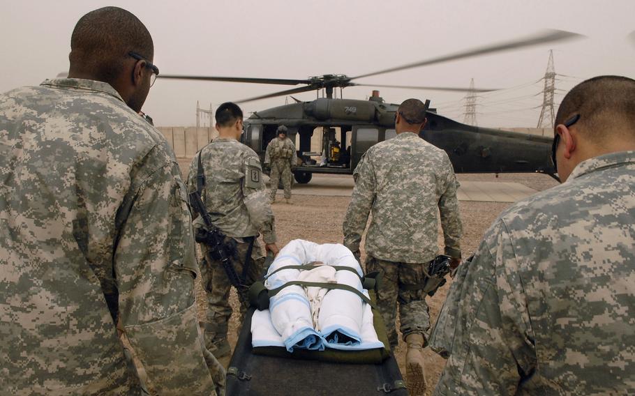 Four combat medics carry a seven month old Iraqi child