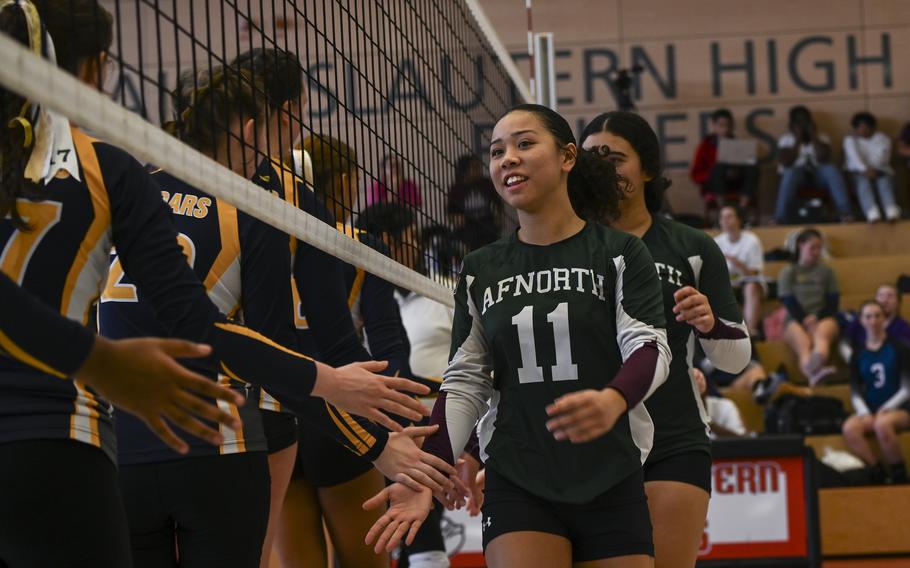 AFNORTH Lion Richele Reyes low-fives Ansbach Cougar opponents beneath the net, marking the teams’ sportsmanship before the start of their match at the DODEA Division III European volleyball semifinals on Oct. 27, 2023, in Kaiserslautern, Germany.